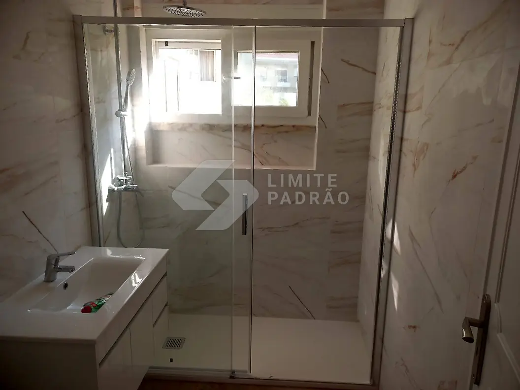 Casa de banho · duche: duche em mármore com resguardo de vidro e móvel branco