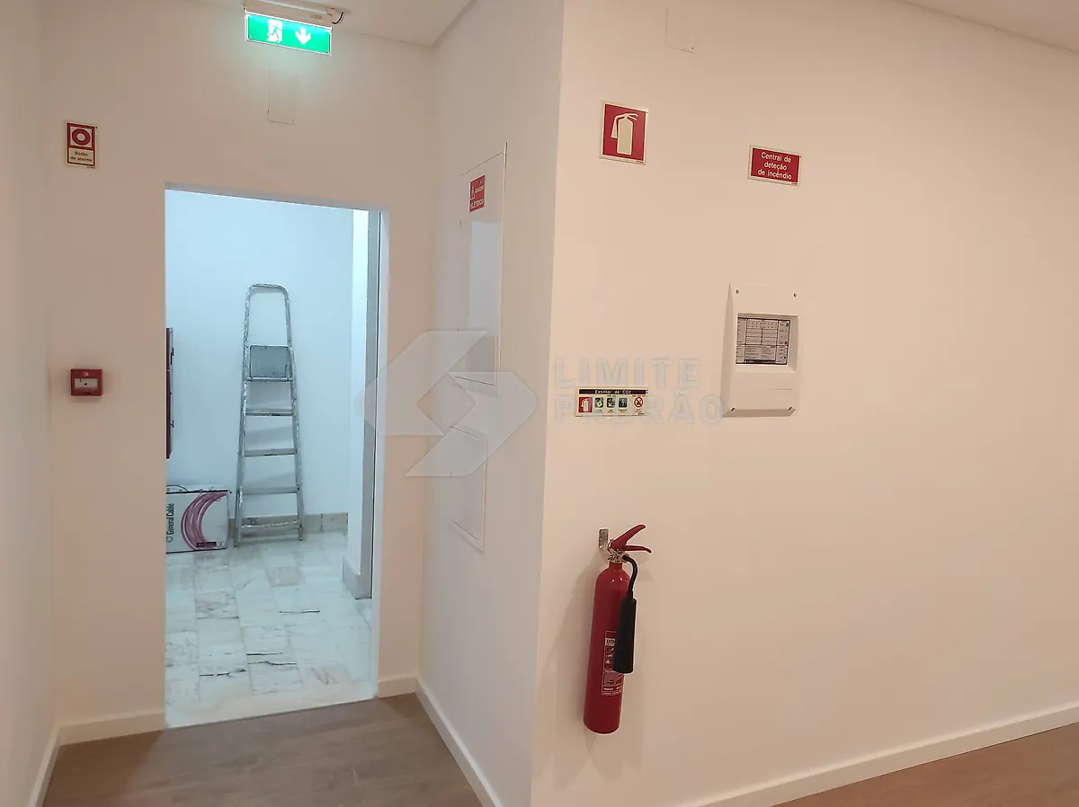 Espaço comercial: corredor com sinalética de segurança e extintores