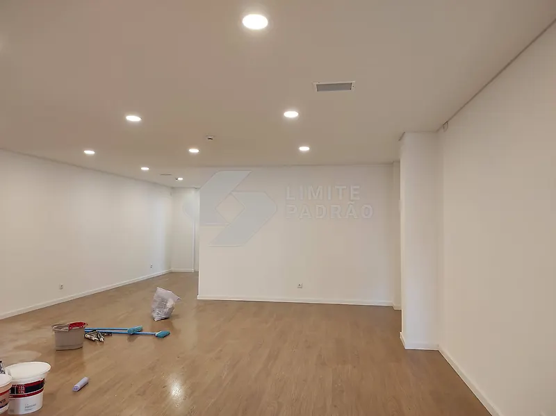 Espaço comercial: sala ampla com pavimento em madeira e iluminação embutida