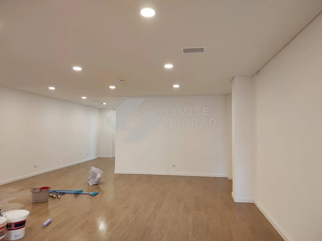 Espaço comercial: sala ampla com pavimento em madeira e iluminação embutida