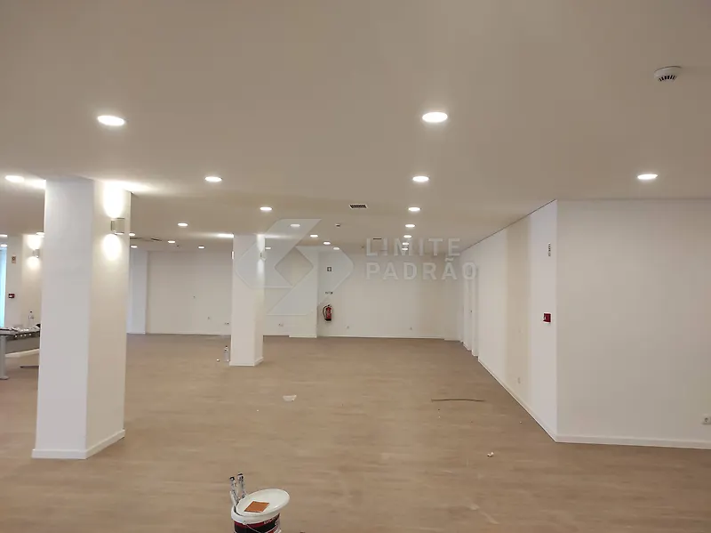 Espaço comercial: open space com pilares e pavimento em madeira