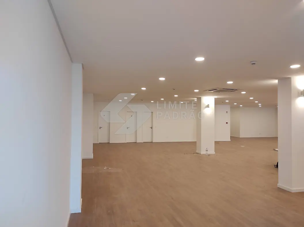 Espaço comercial: sala ampla com pilar central e focos embutidos