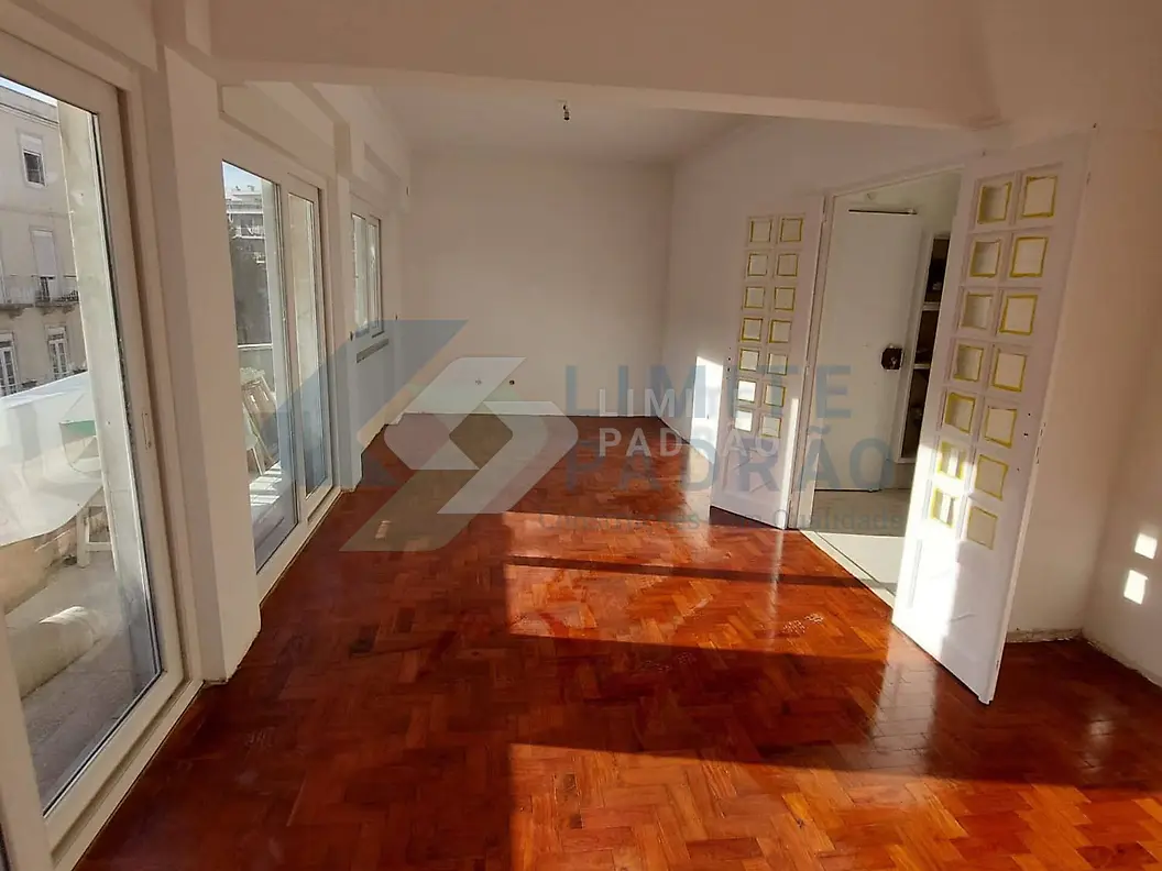 Sala com parquet: parquet envernizado e portas envidraçadas para a varanda