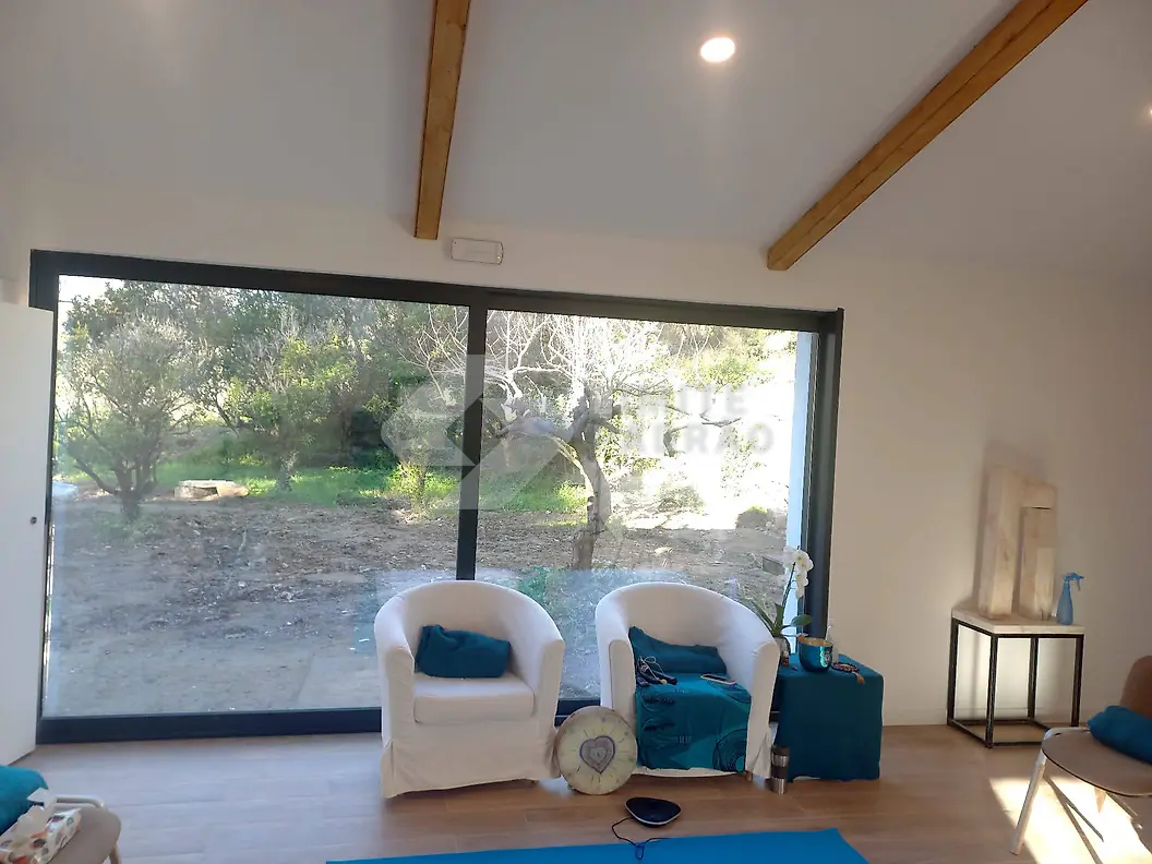Sala: sala com vigas à vista e grande vão para o jardim