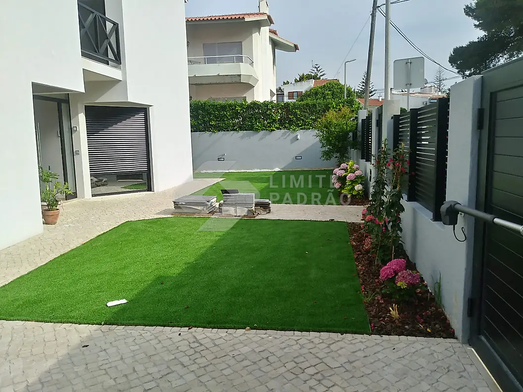 Jardim: jardim de entrada com relva, canteiros e portão
