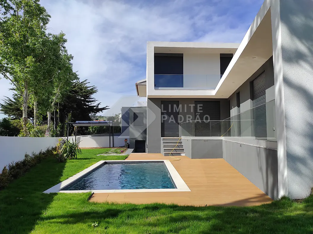Construção de moradia com piscina: moradia e piscina vistas do jardim