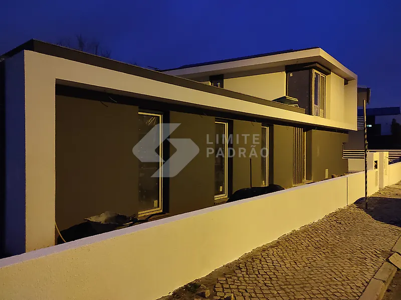 Em obra · fachada: caixilharia colocada e passeio em calçada portuguesa