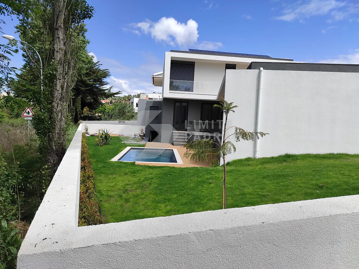 Construção de moradia com piscina: jardim, piscina e painéis solares na cobertura