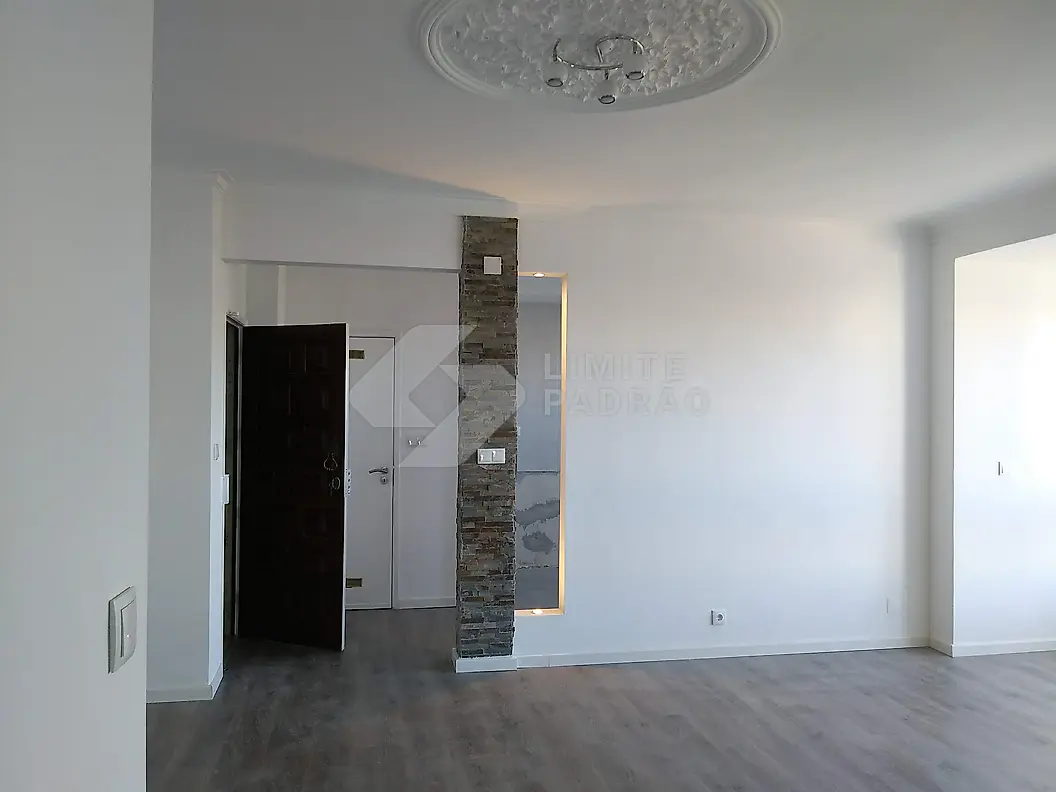 Sala: sala com parede em pedra e florão