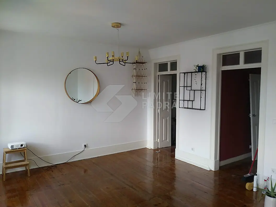 Reabilitação de apartamento: sala com soalho recuperado e portas de madeira