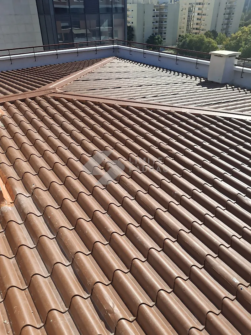 Cobertura em telha nova: telha cerâmica castanha, vista de cima, em prédio urbano