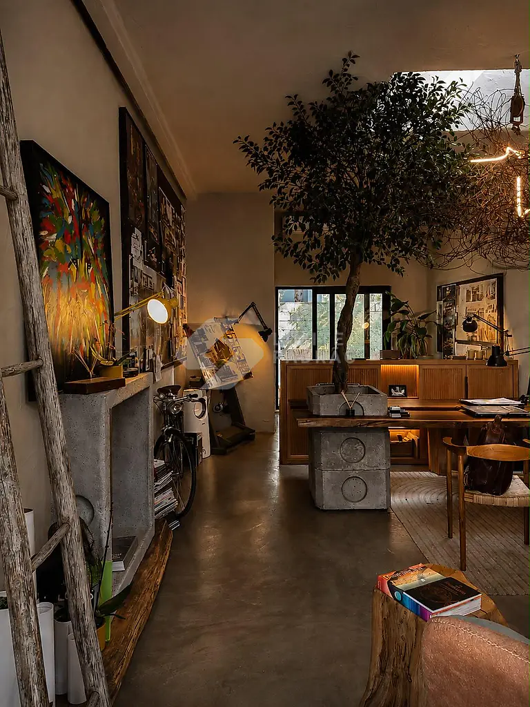 Espaço comercial: atelier com árvore interior, pavimento em cimento afagado e iluminação quente