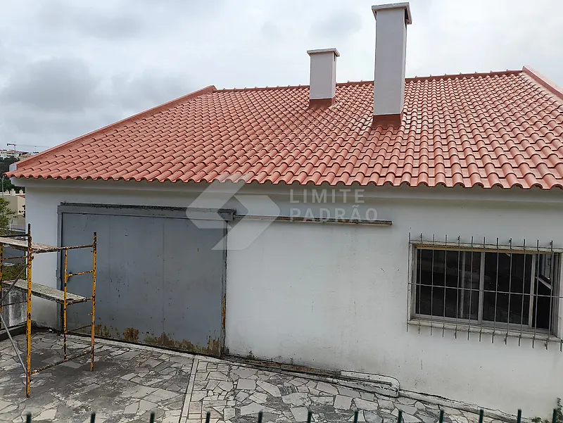 Cobertura nova em moradia térrea: telha vermelha nova e chaminés; andaime ainda montado