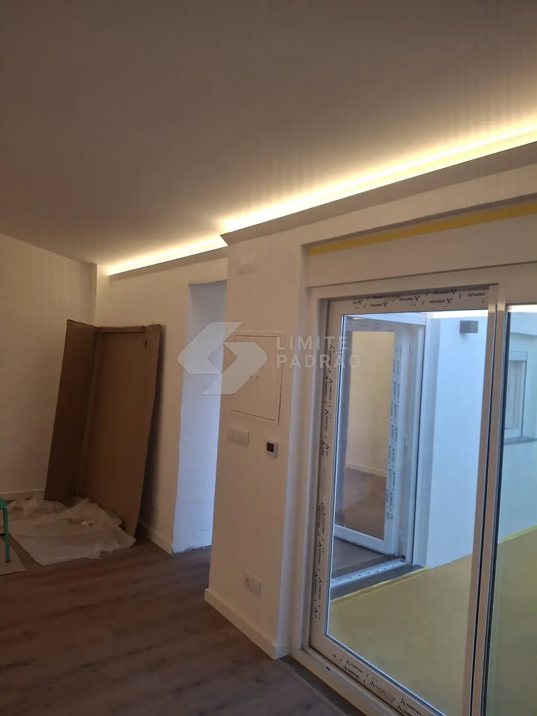 Em obra · quarto: sanca LED, vão para o terraço e chão protegido durante a obra