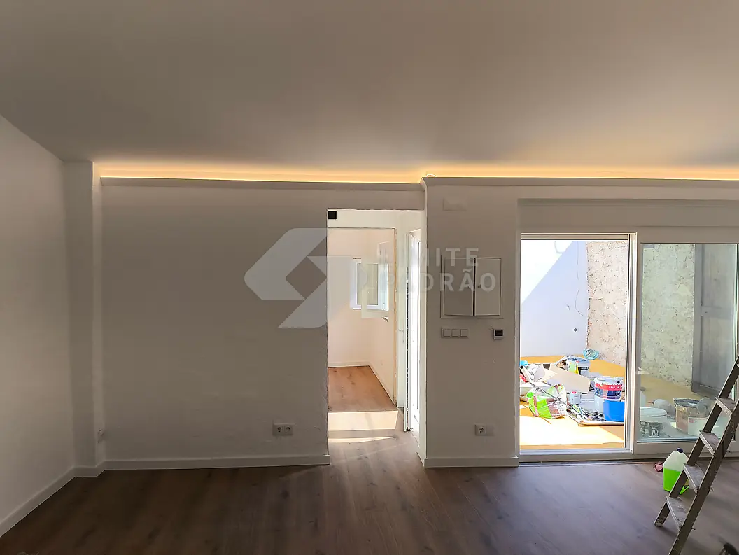 Em obra · sala: iluminação indireta no teto e portas colocadas; obra em fase final