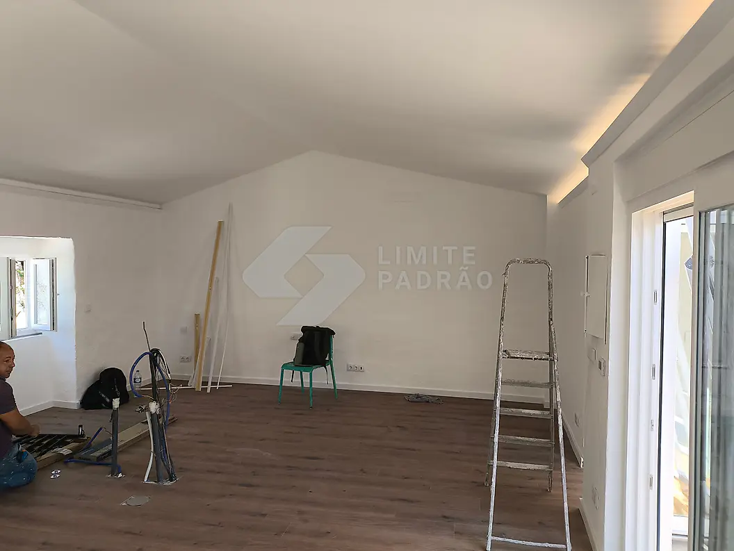 Em obra · sala: pintura e acabamentos em curso, soalho já colocado