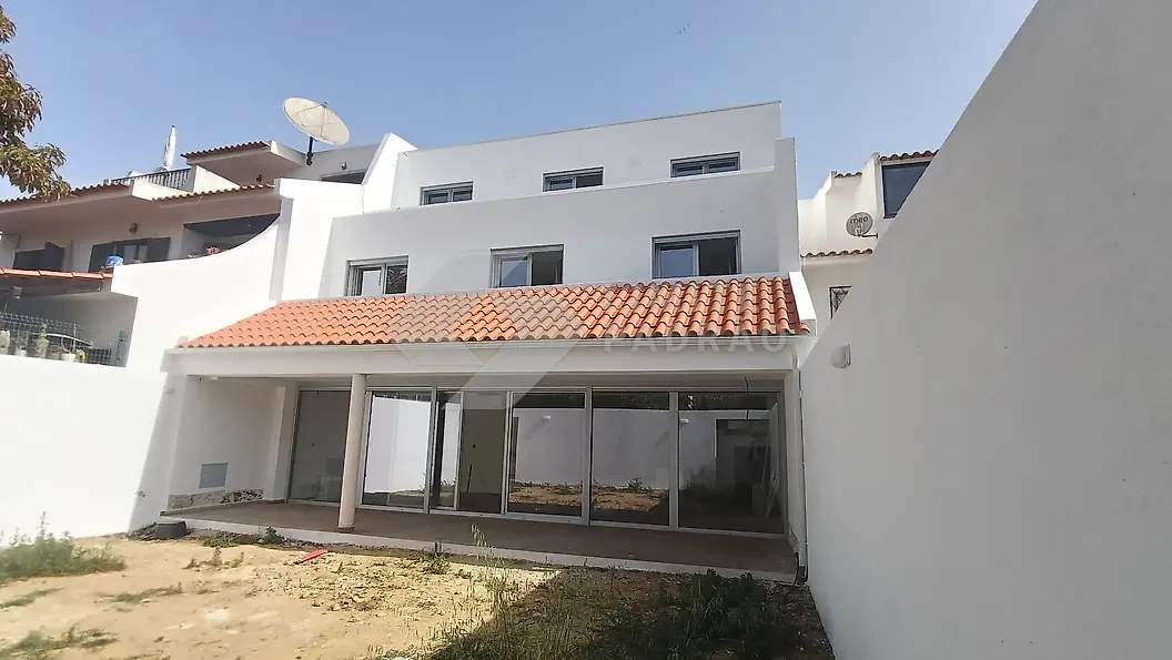 Construção de moradia: alçado tardoz com vãos envidraçados e cobertura em telha; arranjos exteriores por fazer