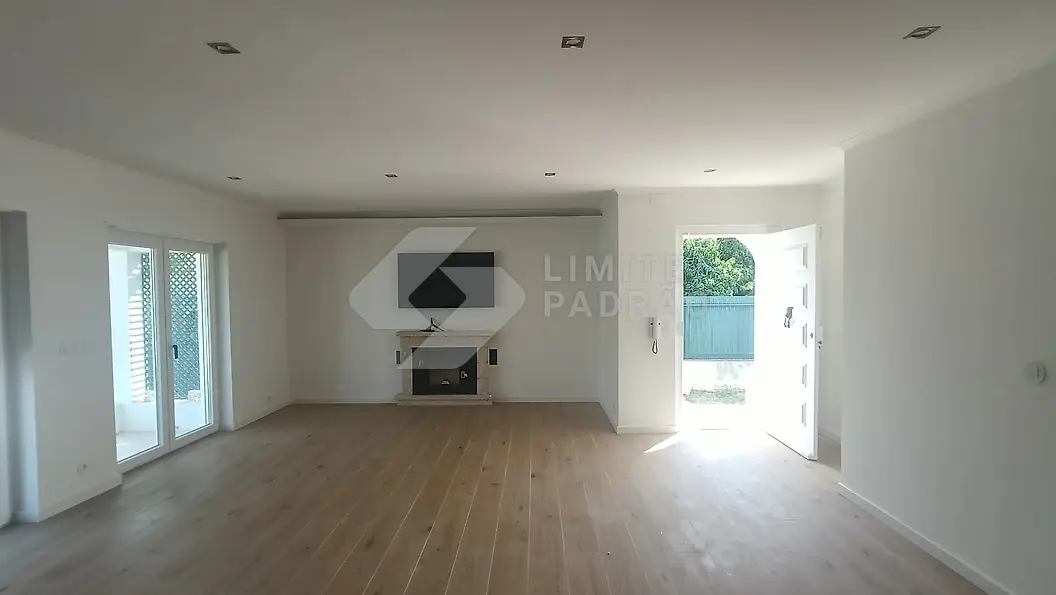 Sala com lareira: sala ampla com lareira, vãos envidraçados de ambos os lados e pavimento em madeira
