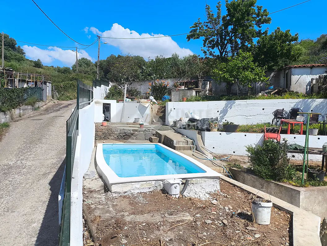Em obra · piscina: piscina e muros em construção, vistos do acesso