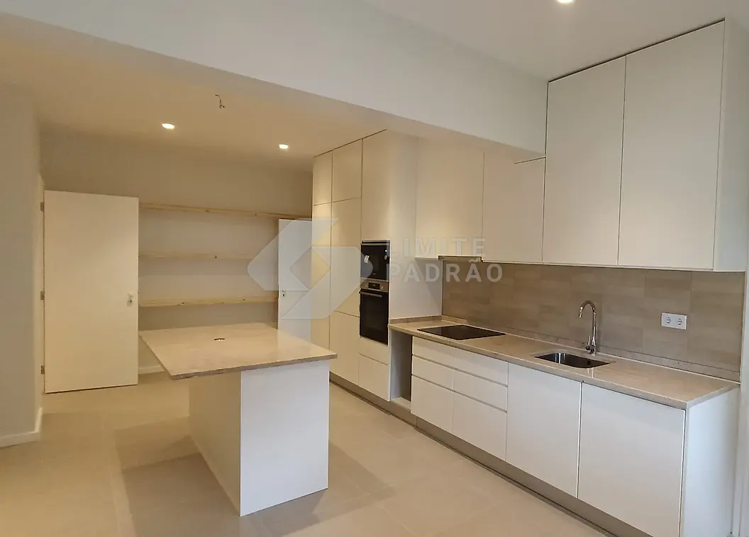 Remodelação de cozinha: cozinha branca com ilha, bancada em pedra e armários até ao teto
