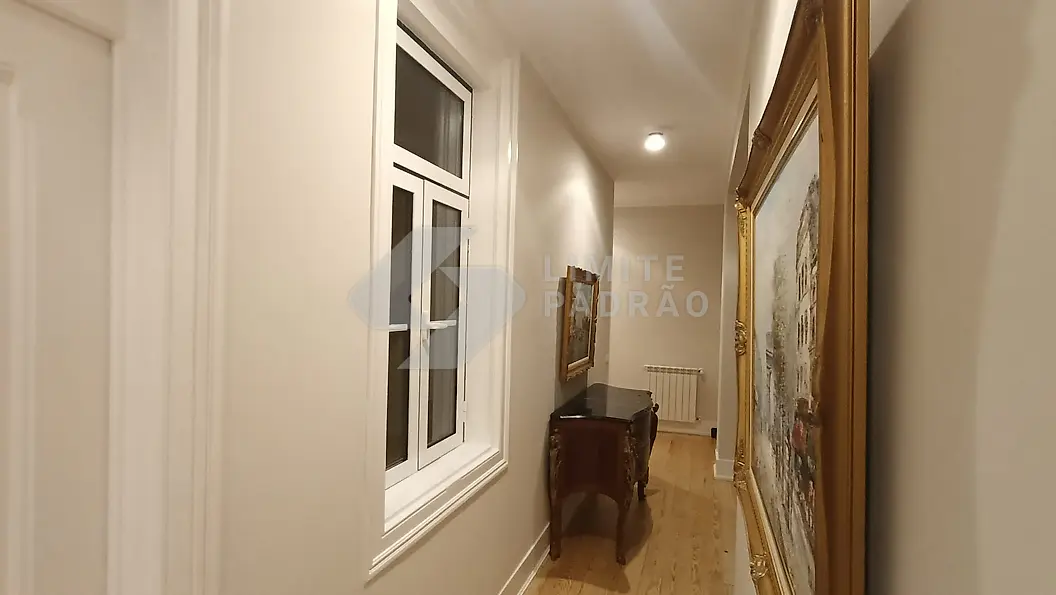 Corredor: corredor de apartamento clássico com janelas em madeira, radiador e quadro