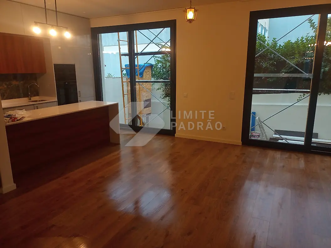Em obra · open space: sala e cozinha quase prontas, proteções ainda no chão