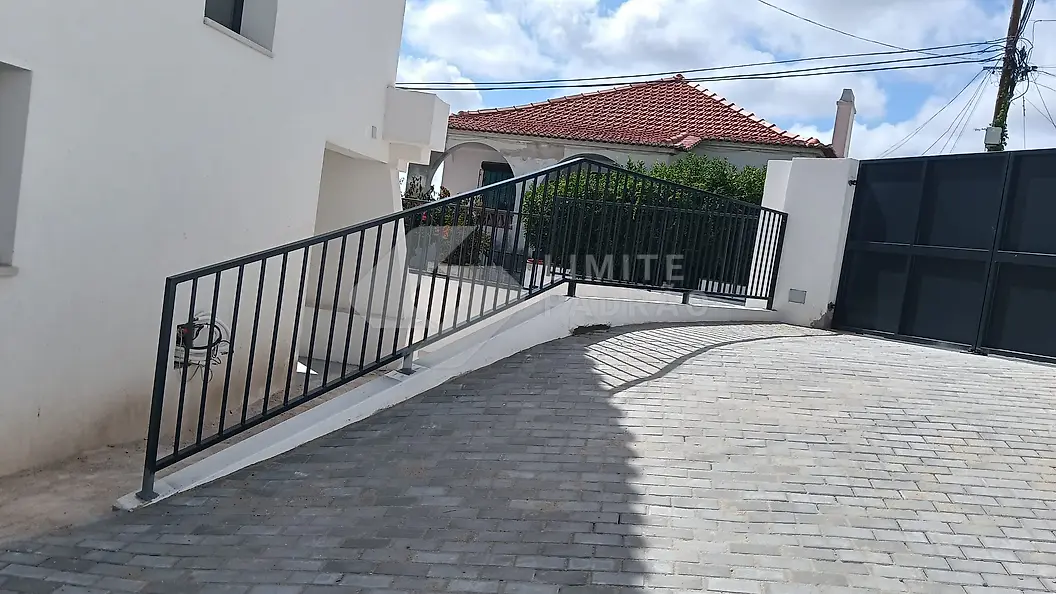 Rampa e portão: rampa de acesso em cubo de granito, guarda metálica e portão