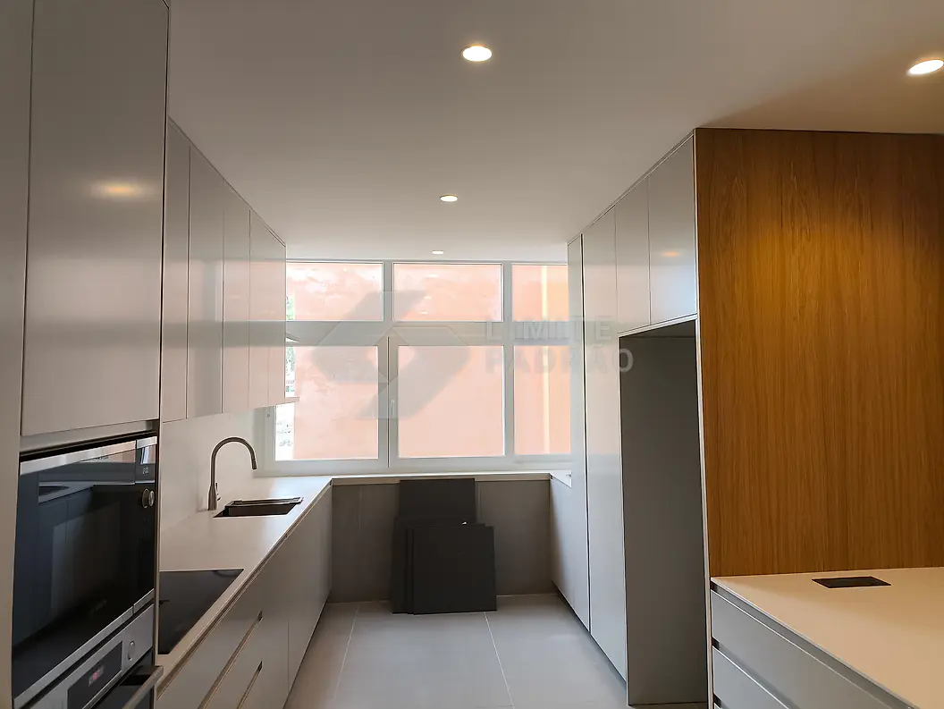 Remodelação de cozinha: cozinha cinza com coluna de fornos e armários em madeira