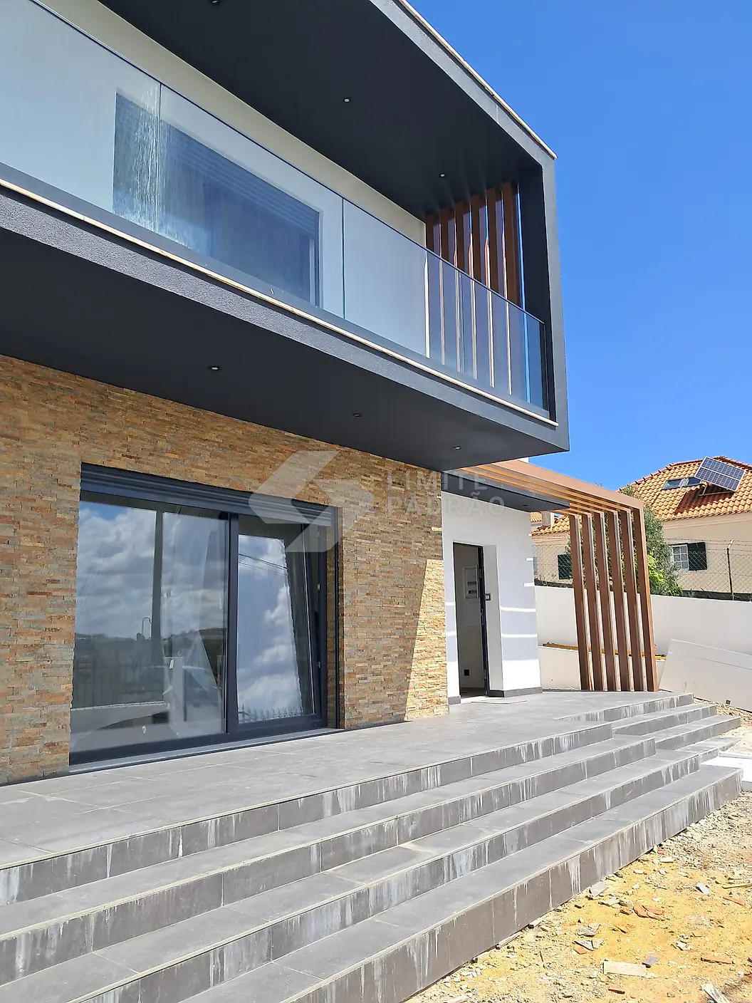 Construção de moradia: entrada com escada e revestimento em pedra
