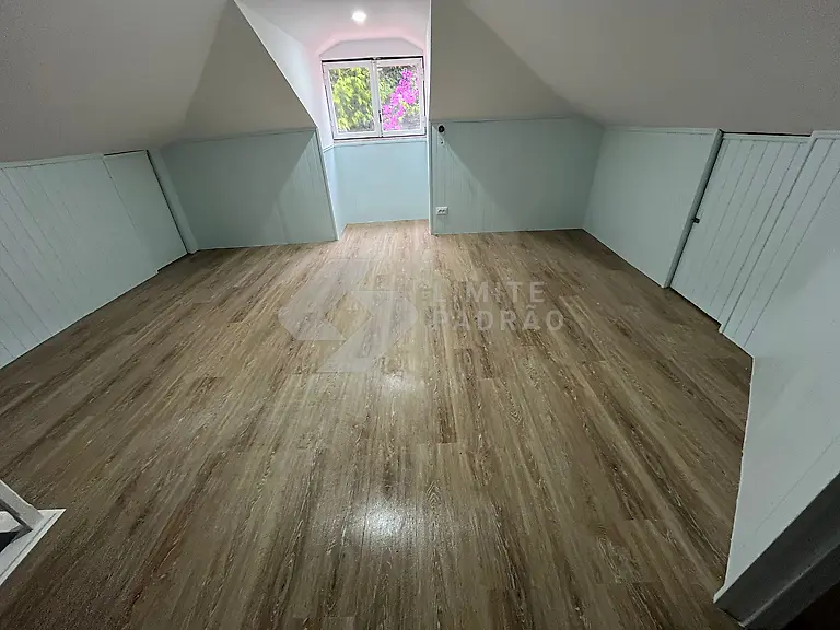 Sótão: sótão transformado em divisão, com lambrim branco e pavimento novo
