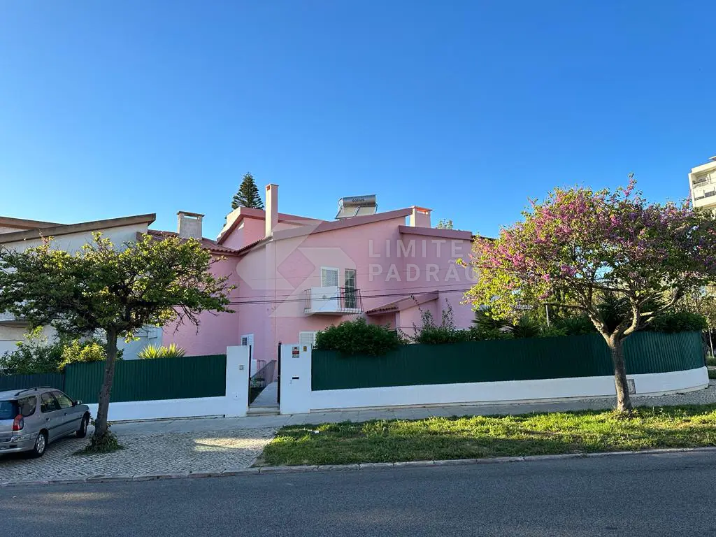 Remodelação de moradia: moradia rosa vista da rua, com muro e portão