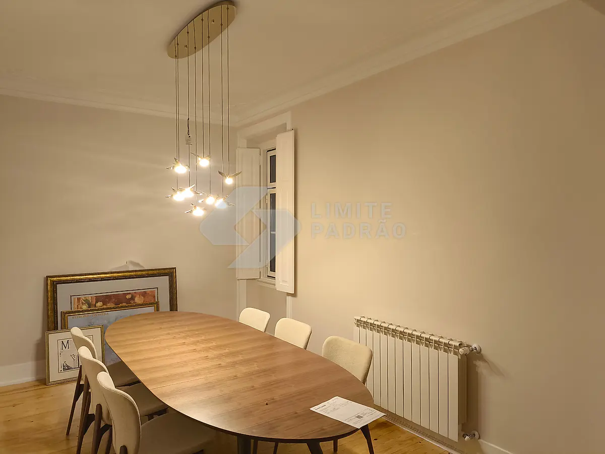 Sala de jantar: mesa oval, candeeiro suspenso e janelas de guilhotina