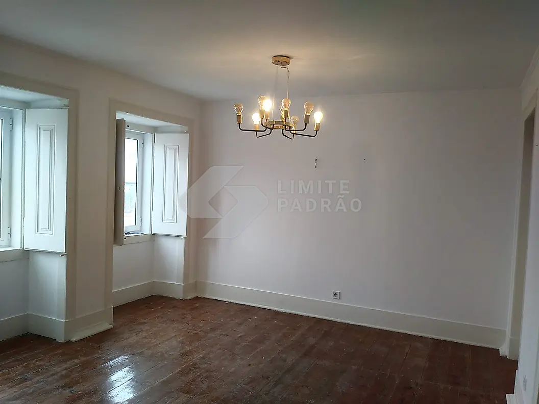 Reabilitação de apartamento: sala com lustre, portadas e soalho recuperado